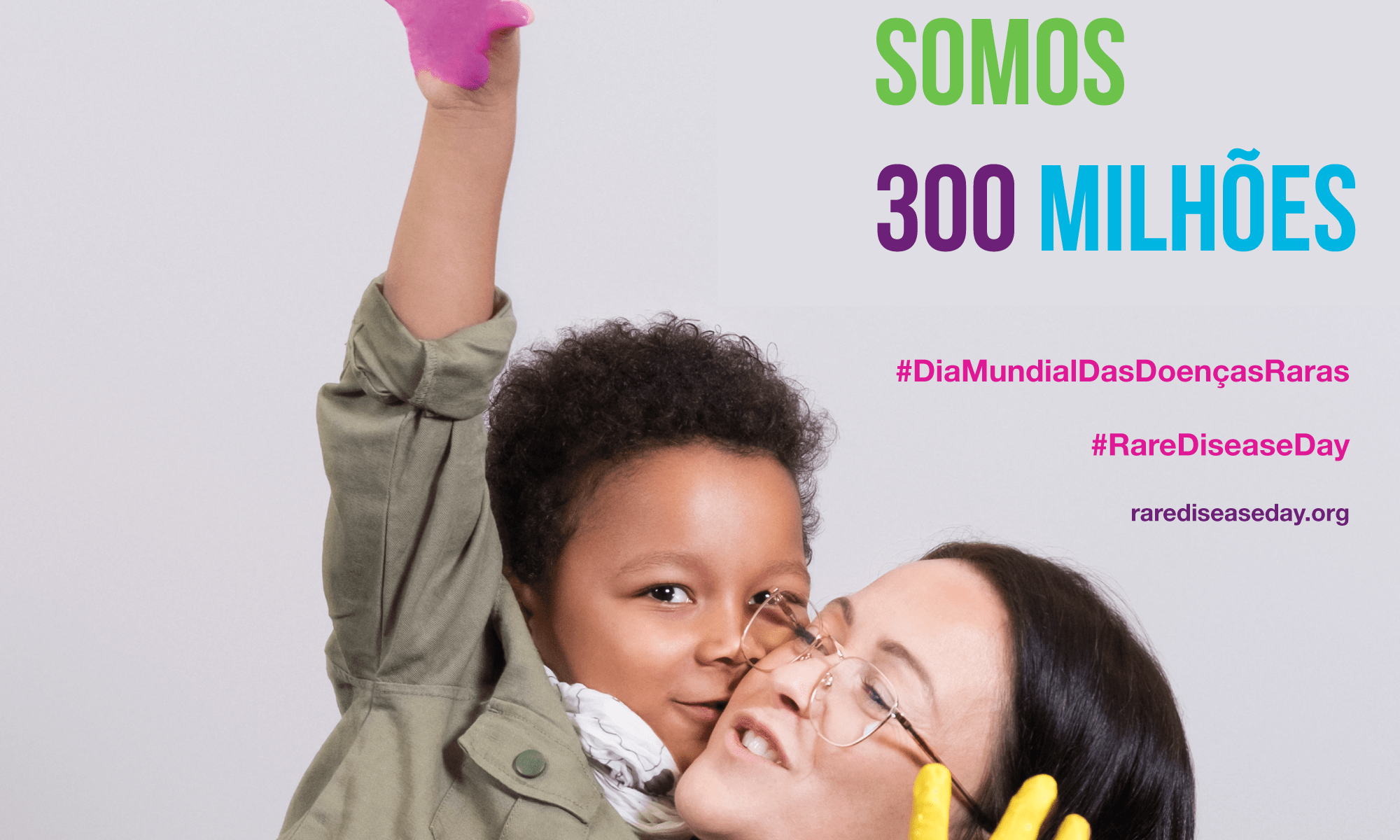 #PraCegoVer imagem ilustrativa. Está escrito "Somos 300 milhões" Há a foto de uma mulher e um menino sorrindo e se abraçando, eles têm as palmas das mãos pintadas. Há ainda as #: #DiaMundialDasDoençasRaras e #RareDiseaseDay. Há o link rarediseaseday.org e a Logo da Rare Disease Day e da Retina Brasil.