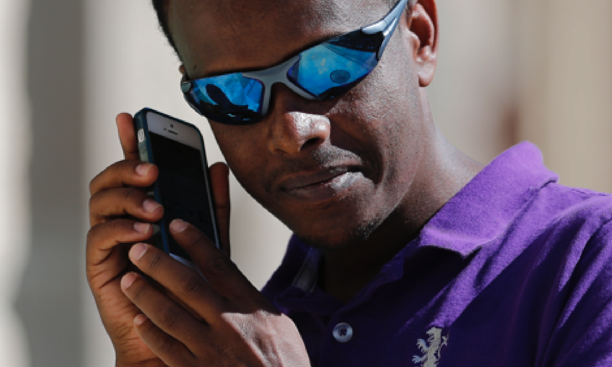 #PraCegoVer foto de um homem usando um celular com o leitor de tela ativado.