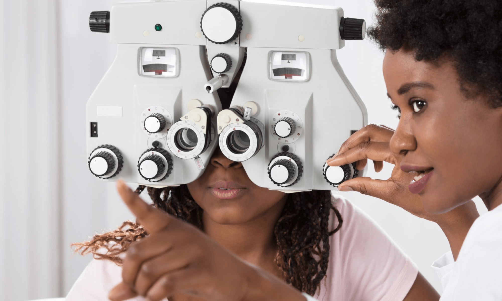 #PraCegoVer imagem ilustrativa. Há duas mulheres, uma médica oftalmologista e uma paciente durante uma consulta. Está escrito "07 de maio Dia Nacional do Oftalmologista". Há as logos da Retina Brasil e da Novartis.