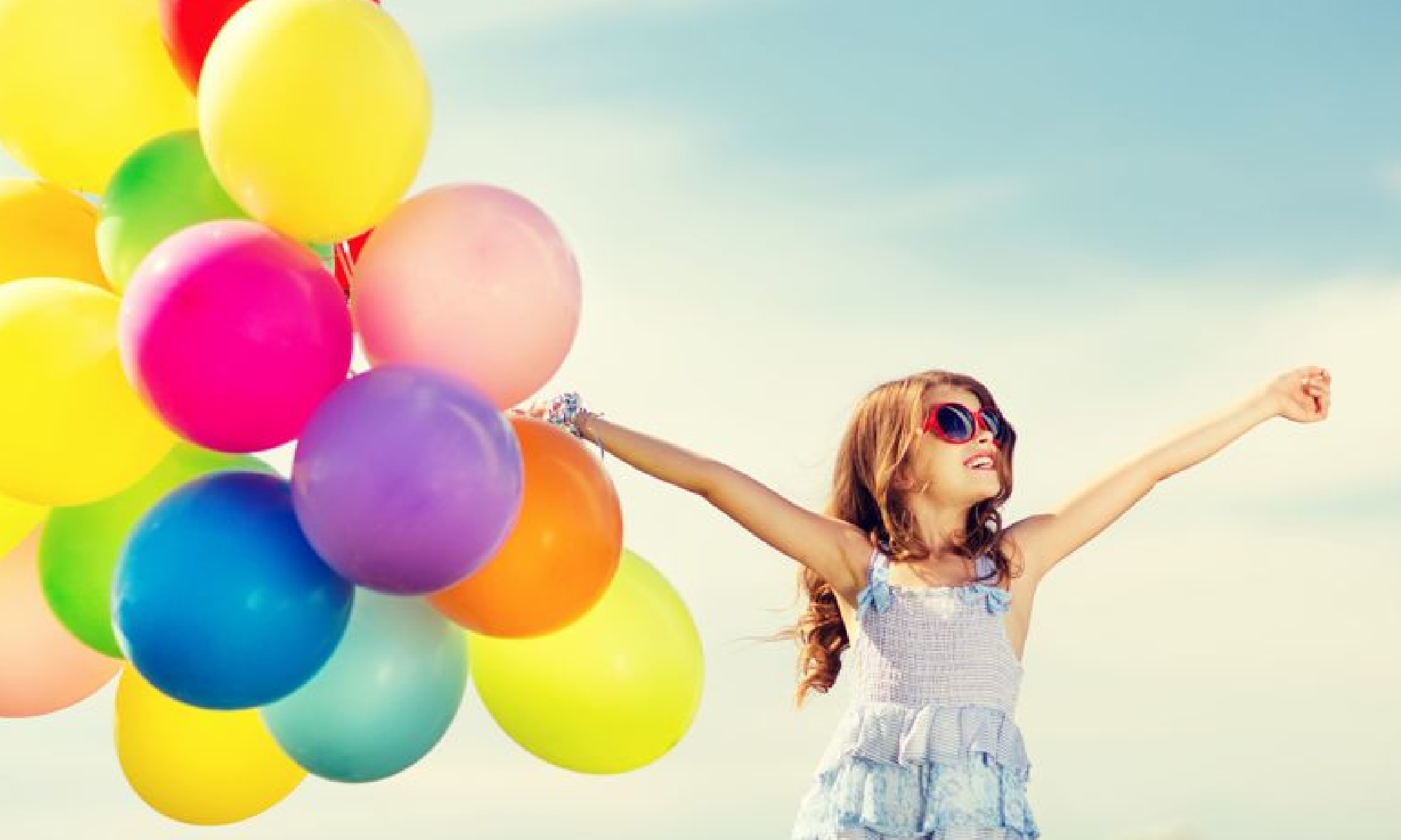 #PraCegoVer imagem de uma menina de óculos escuros segunrando um cacho de balões coloridos. Está escrito: "Qualidade de Vida" e há a logo da Retina Brasil